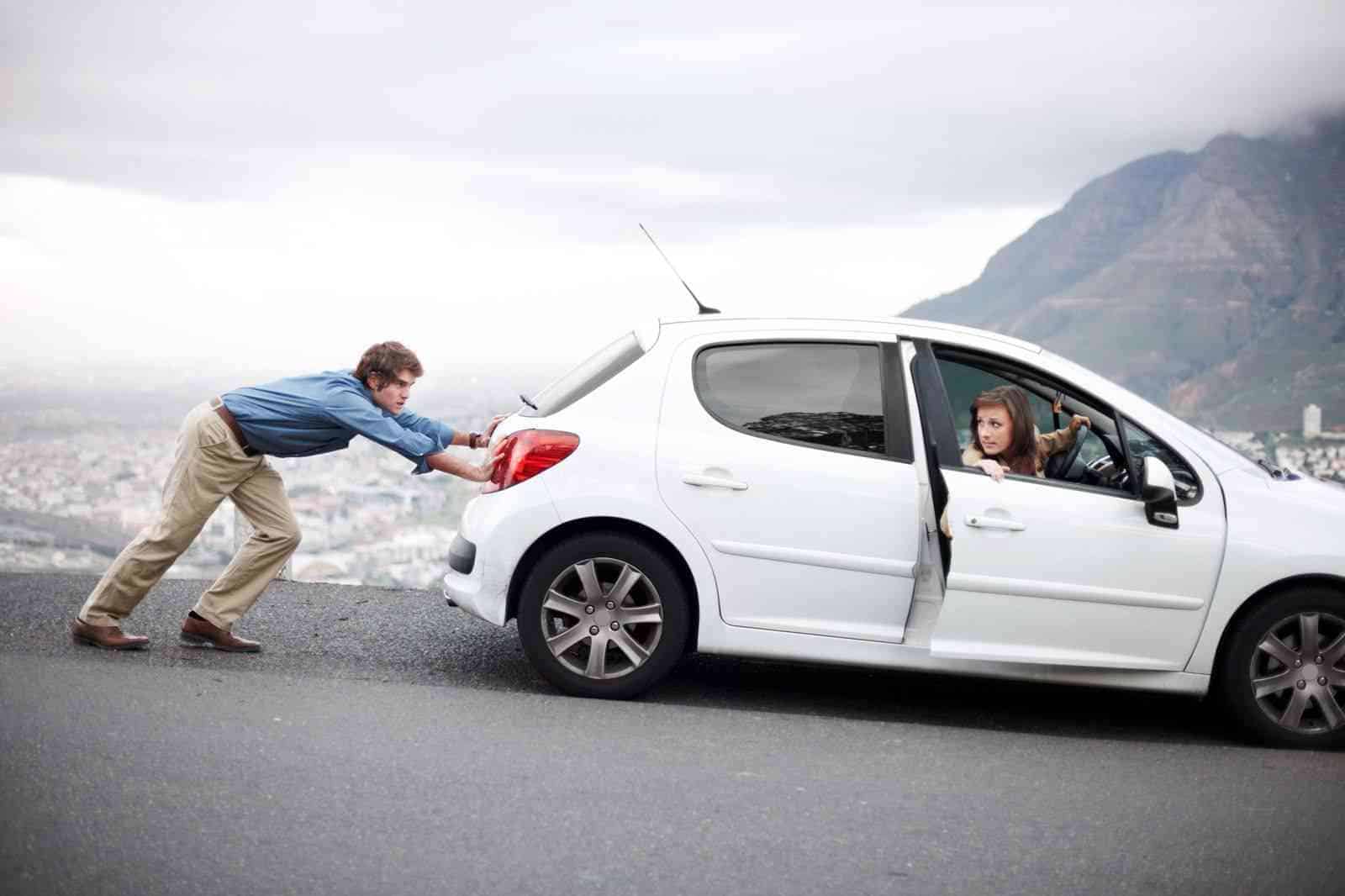 A man pushing a woman out of a white car.